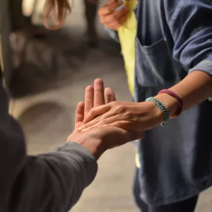 A photo of one person reaching out a hand to another to help.