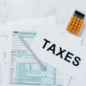 Top view of tax forms, a calculator, and pen for tax preparation.